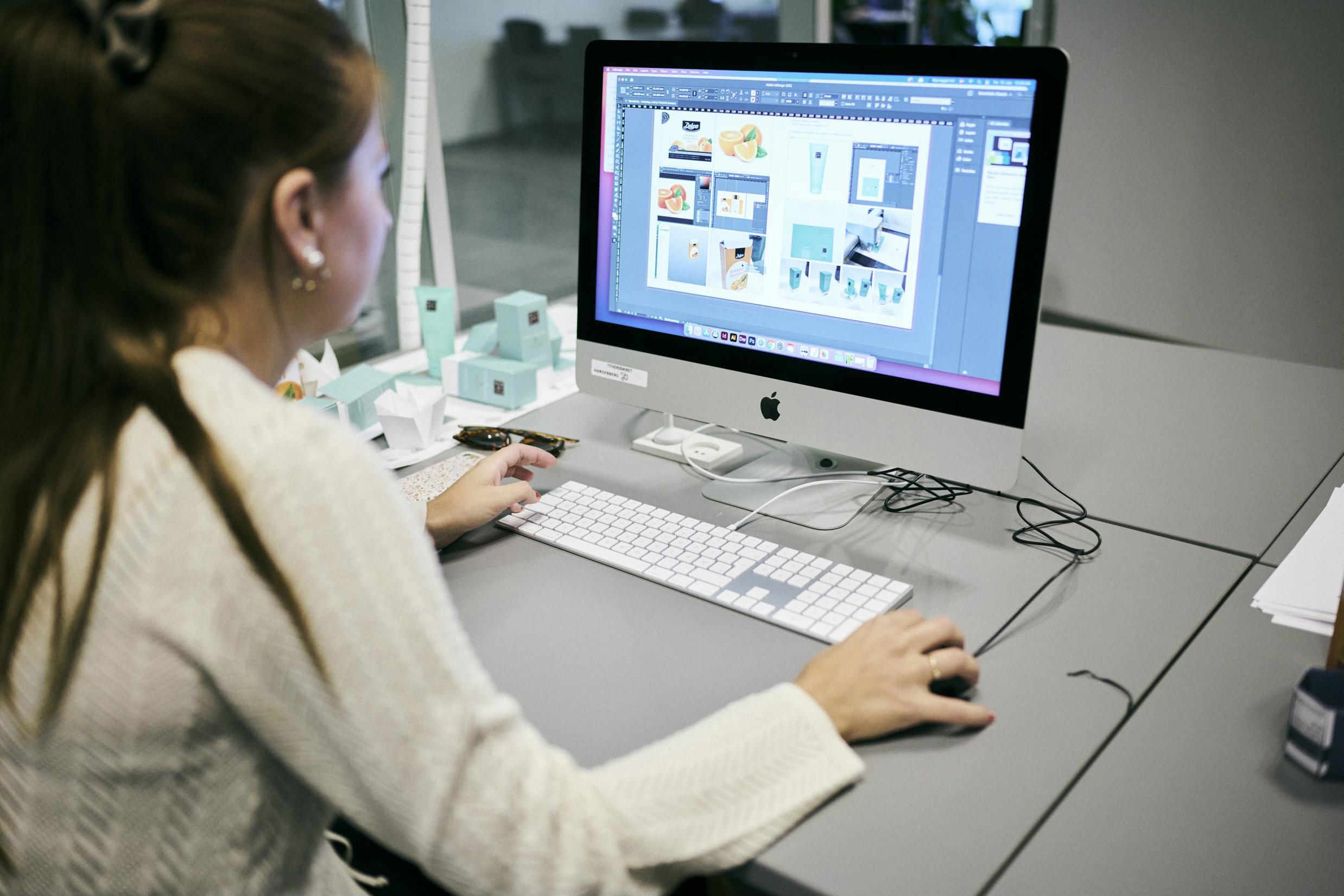 En mediegrafikerelev på Hansenberg designer små æsker med tryk på en af skolens iMacs.