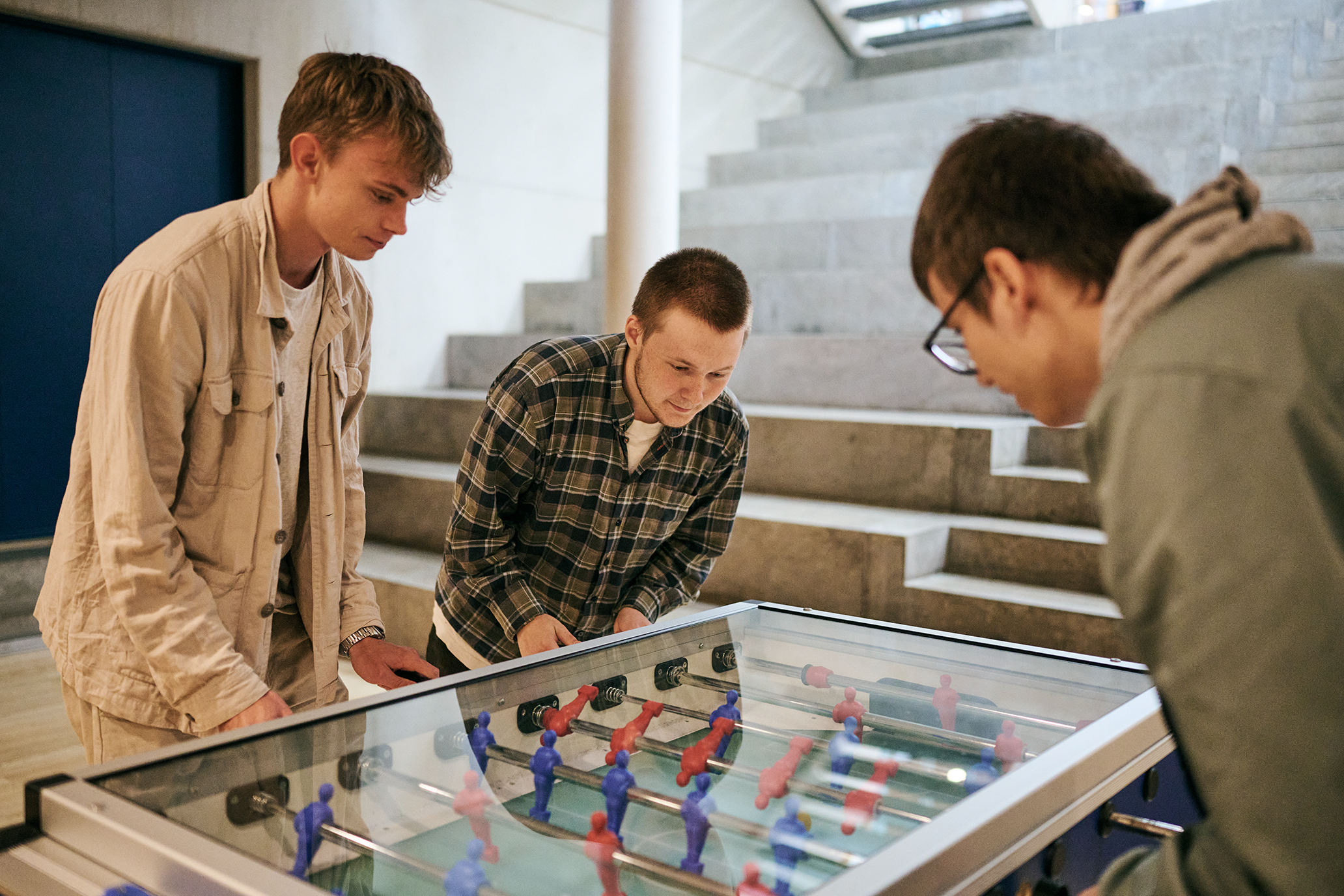 I kælderen på Skovvangen, kan eleverne spille bordfodbold, her er det 3 htx-elever der spiller.