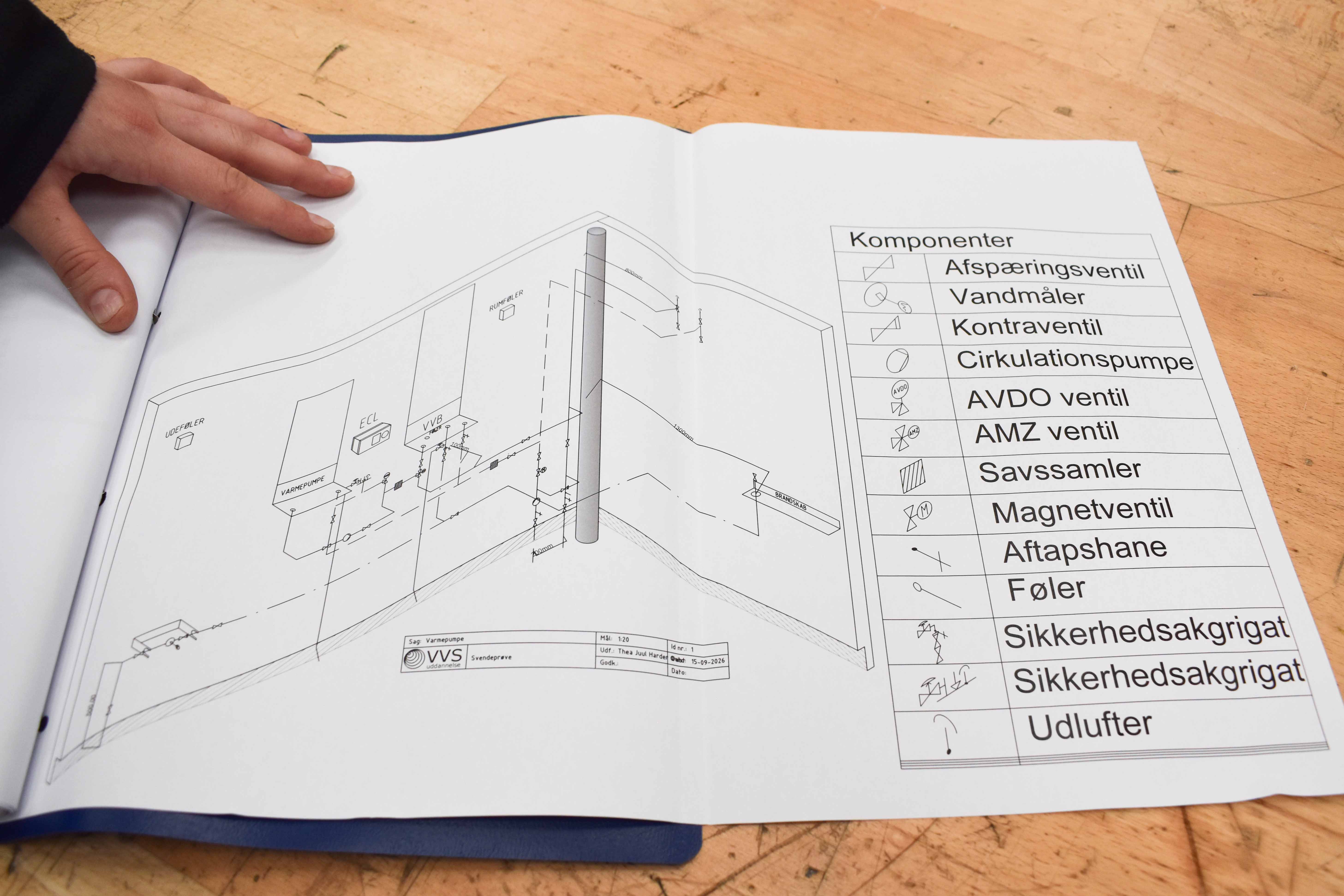 VVS-energispecialist Thea Qvist viser her tegningerne til sit svendestykke til tre 12-taller.