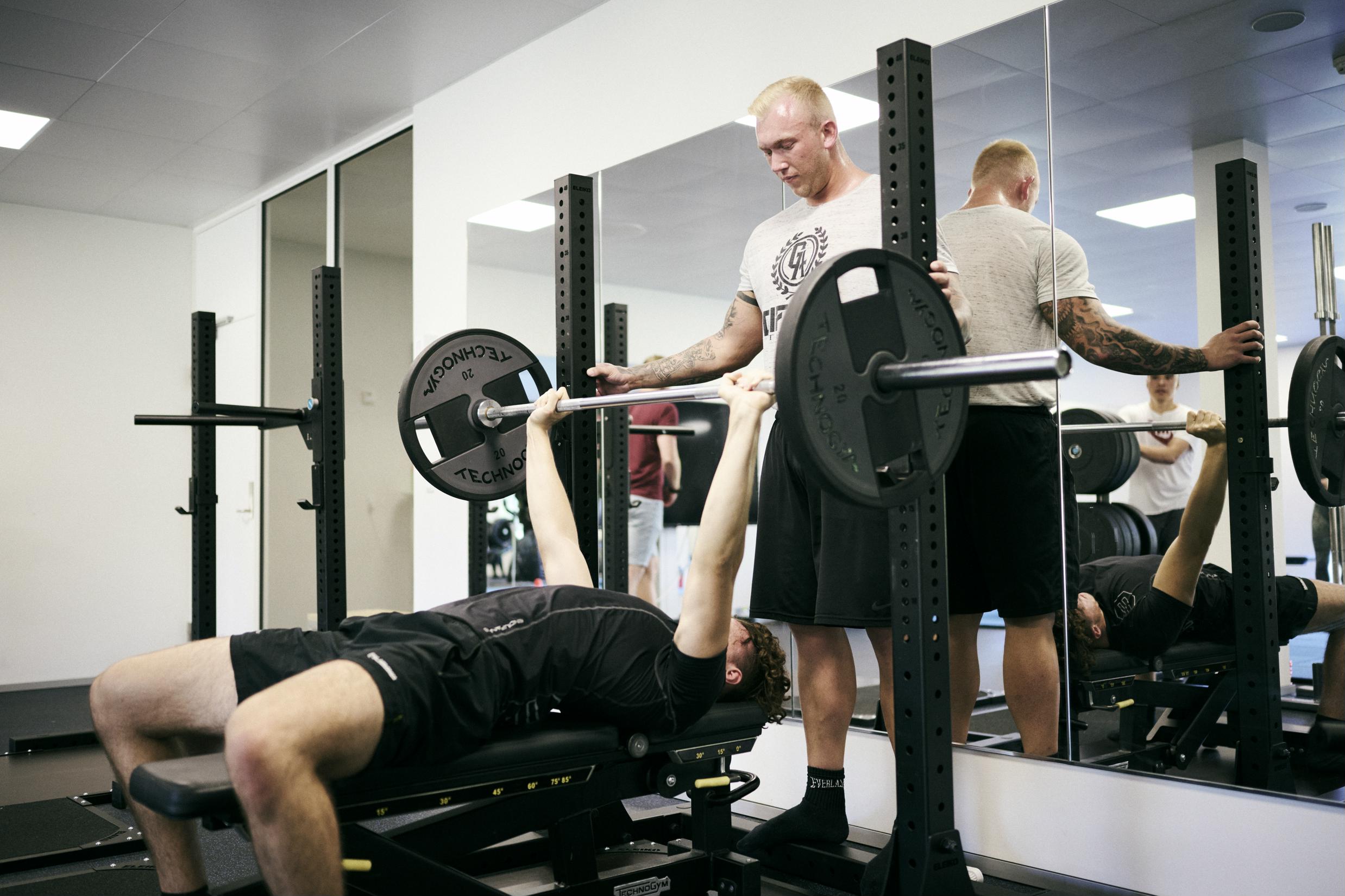Eleverne på Fitness- og træneruddannelsen skal blandt andet coache hinanden, og her er det 2 elever coacher og træner vægtløftning..
