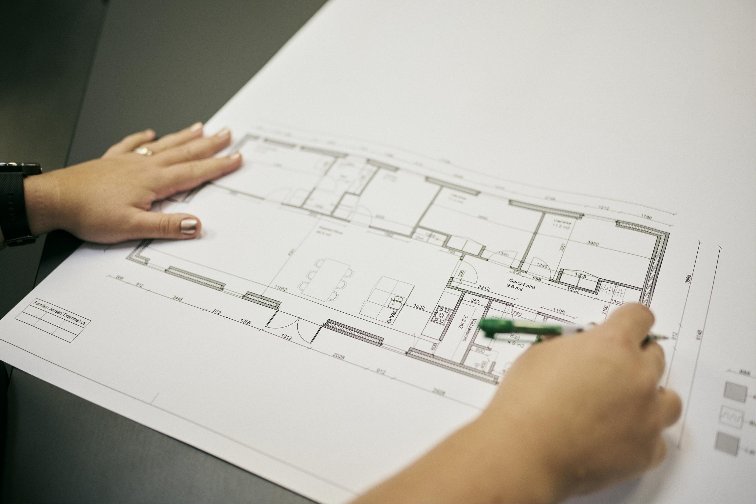 en teknisk designerelev kontrollerer sin egen plantegning.