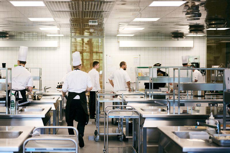 Et hold kokkeelever arbejder i skolens undervisningskøkken.