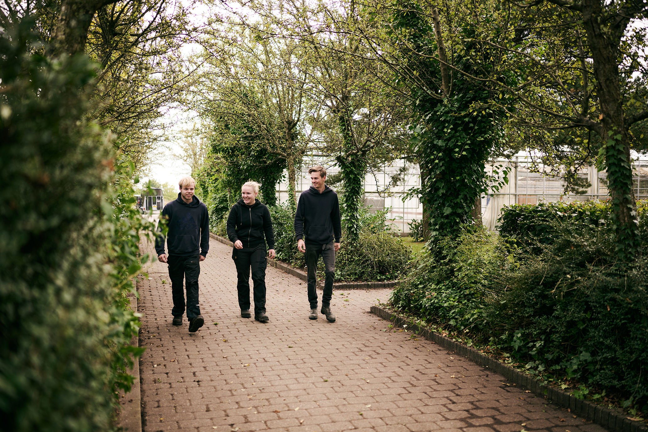 Nogle af eleverne på Hansenbergs adresse i Vranderup er på vej fra parkeringspladsen og går forbi drivhusene hen til undervisningsbygningerne.
