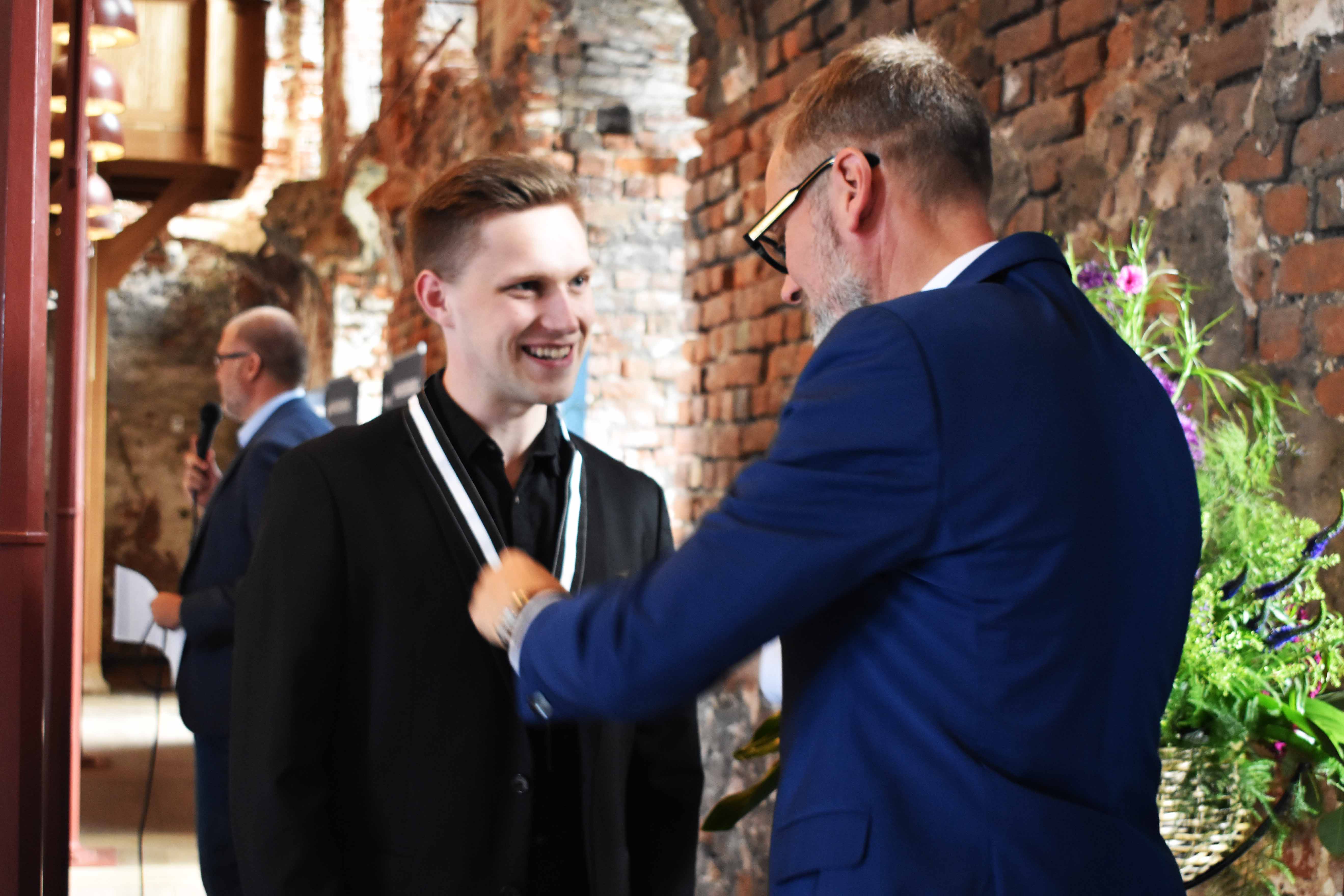 Borgmester i Kolding Kommune Jakob Ville overrækker HANSENBERG-medaljen til tjener Alexander Beck Ringhauge Kristensen.