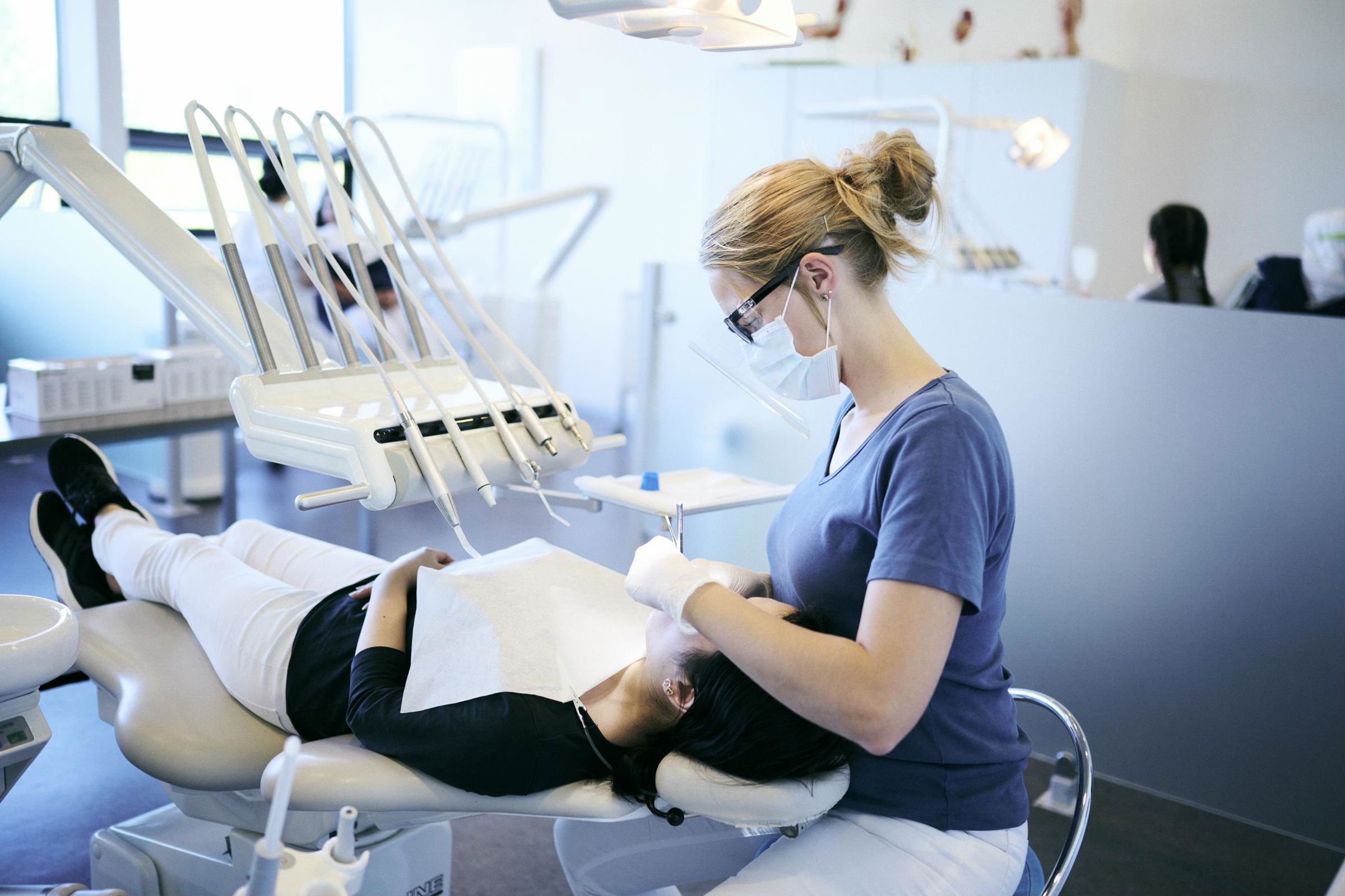 Tandklinikassistenteleverne øver sig i tandrensning på frivillige i Hansenbergs tandklinik.