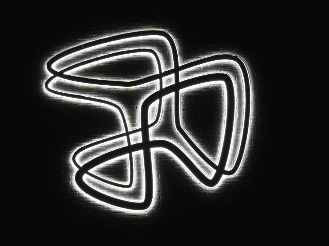 Hansenbergs logo ses oplyst på muren en mørk aften.