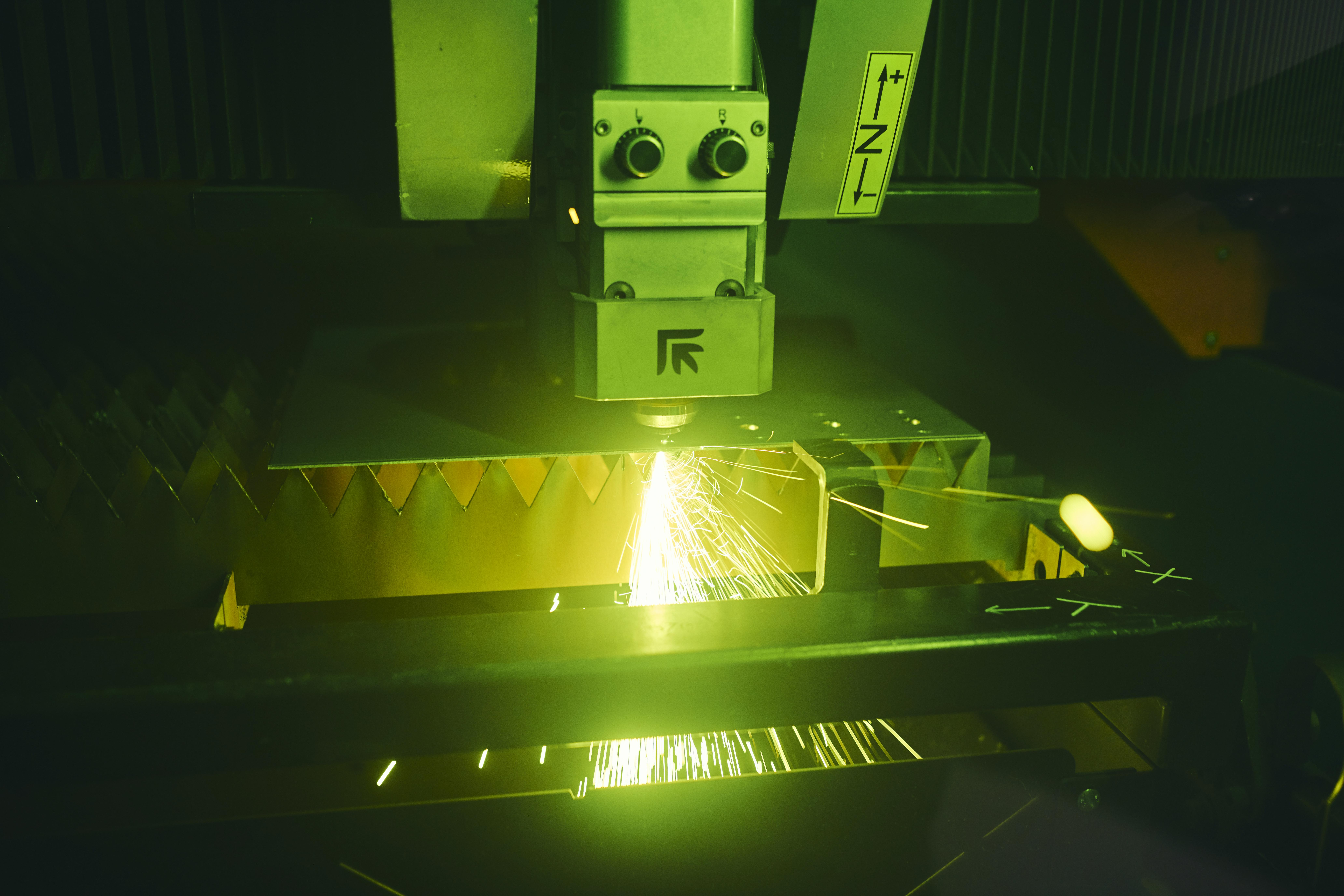 Her ses den store fiberlaser på Hansenbergs smedeværksted i færd med at skære små huller i en jernplade.