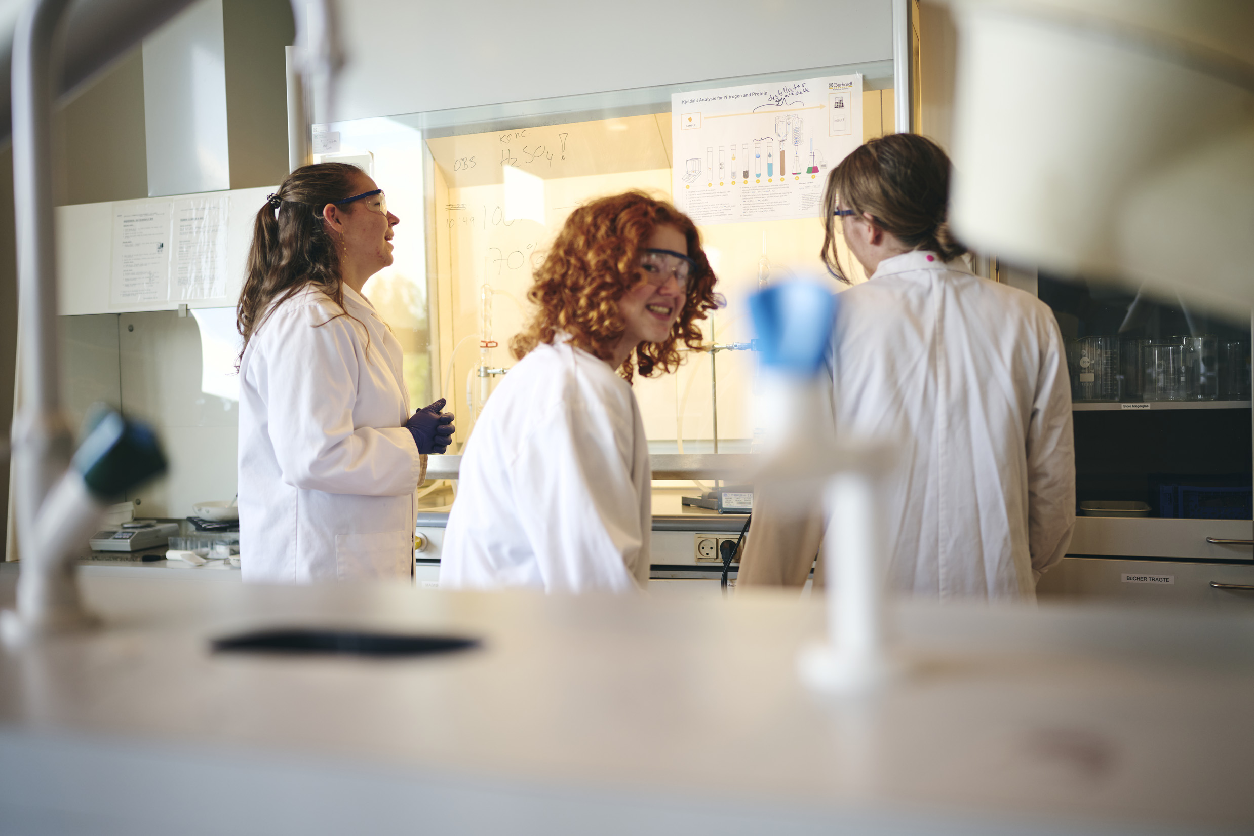 Tre elever på Hansenberg Tekniske Gymnasium udfører forsøg på skolens laboratorium.