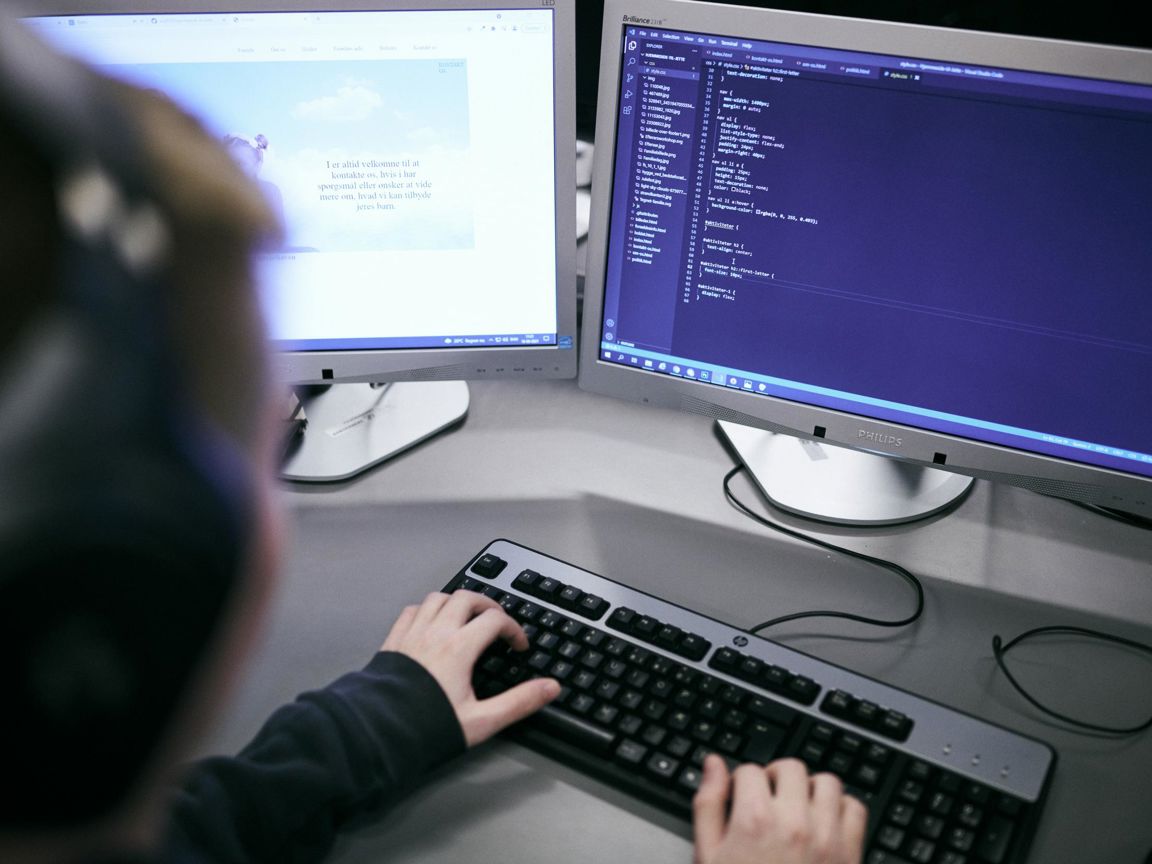 En elev på Hansenbergs webudvikleruddannelse sidder og koder på en af Hansenbergs computere.