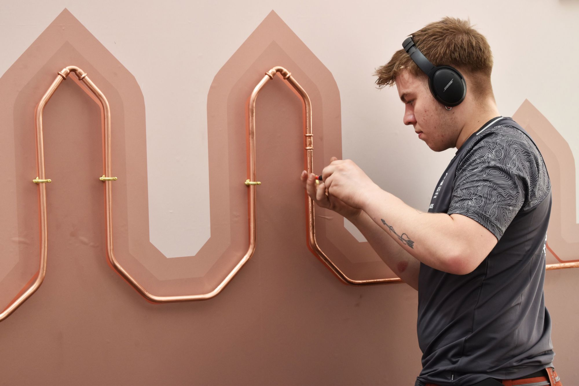 Mads, der er vvs-energispecialistlærling, er ved at opsætte kobberrør efter tegning til DM i Skills 2024.