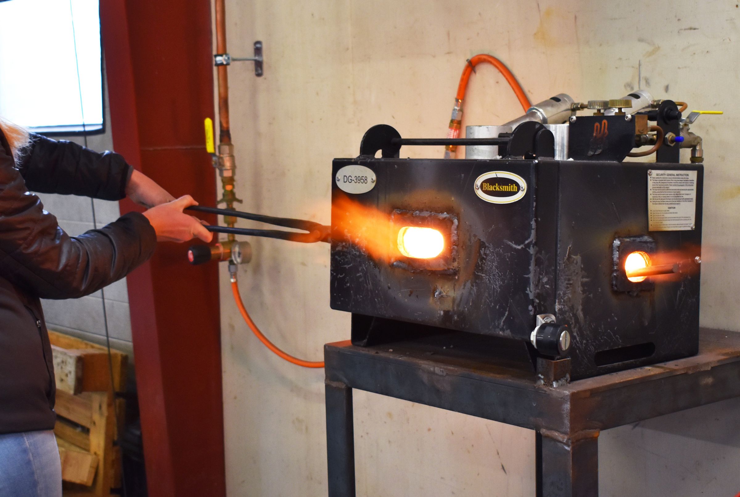 En af deltagerne til Prøv et fag for elever i 4.-10. klasse, er ved at smede hestesko, og lægger hesteskoen til opvarmning i essen.