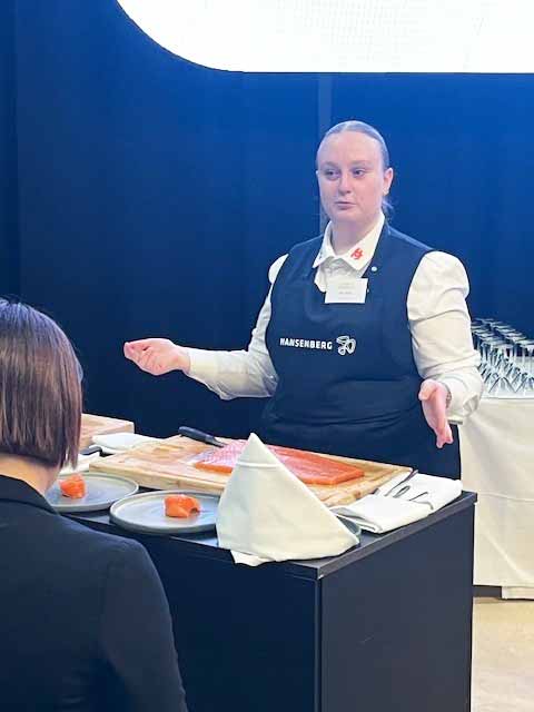 Ida Olsen er tjenerelev på HANSENBERG, og her trancherer hun laks.