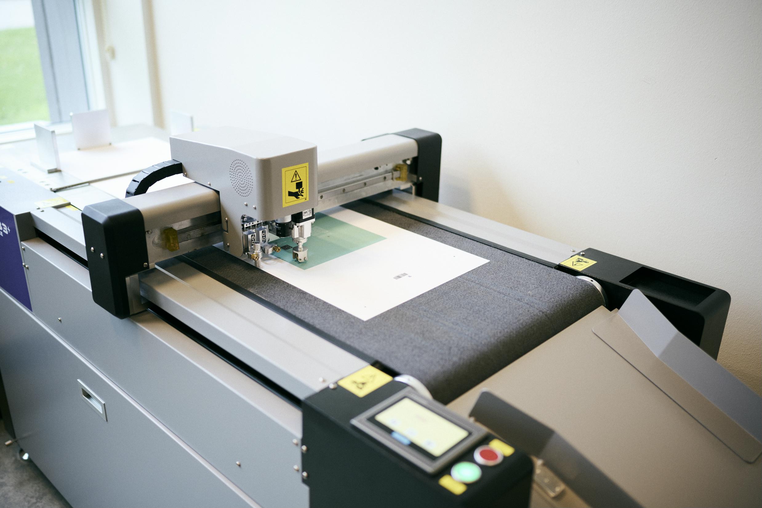 Den digitale skæremaskine på Hansenbergs mediegrafikeruddannelse kan skære meget præcist ud efter elevernes design.