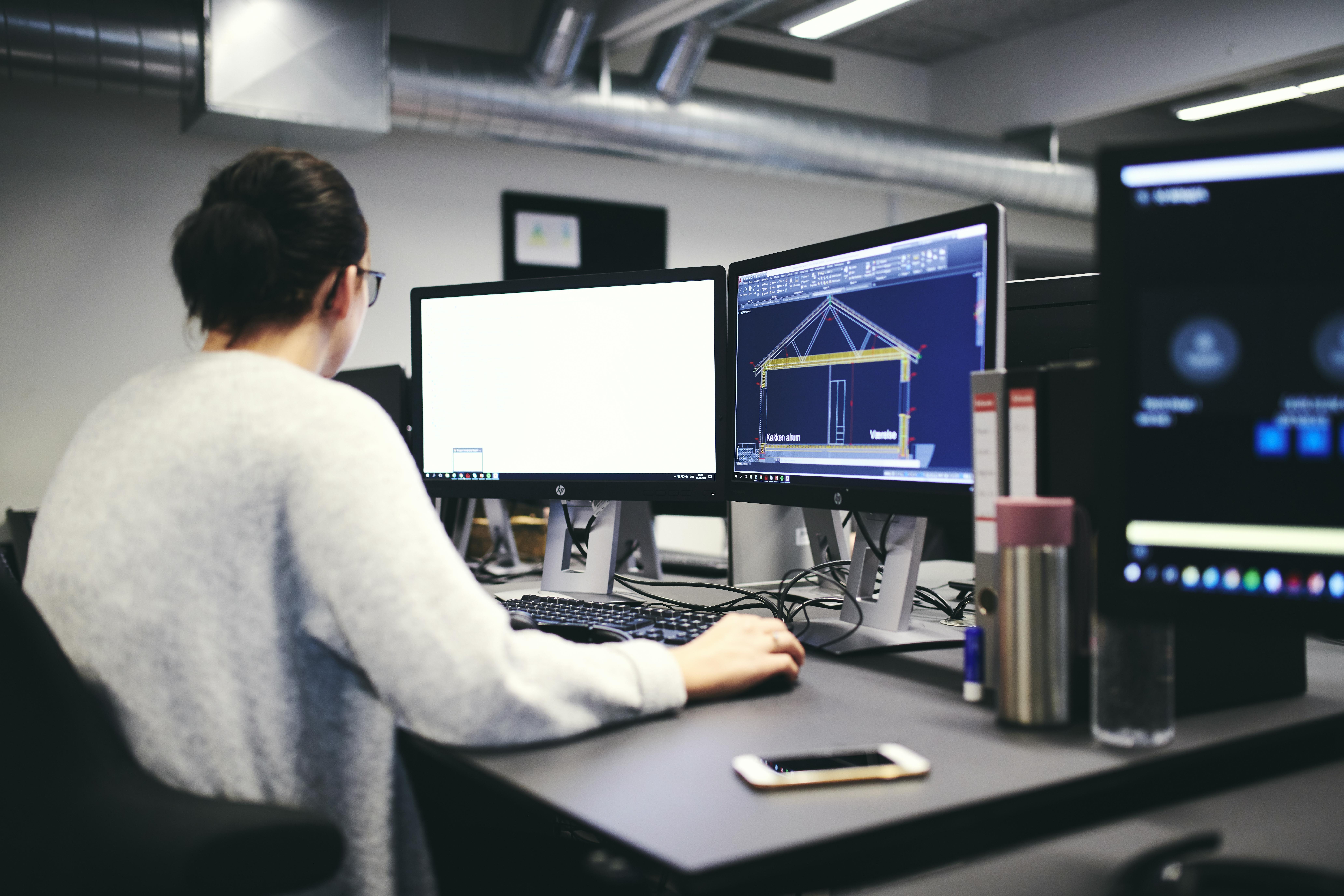 En teknisk designerelev er ved at designe en bygning inkl. mål på isolering mv.