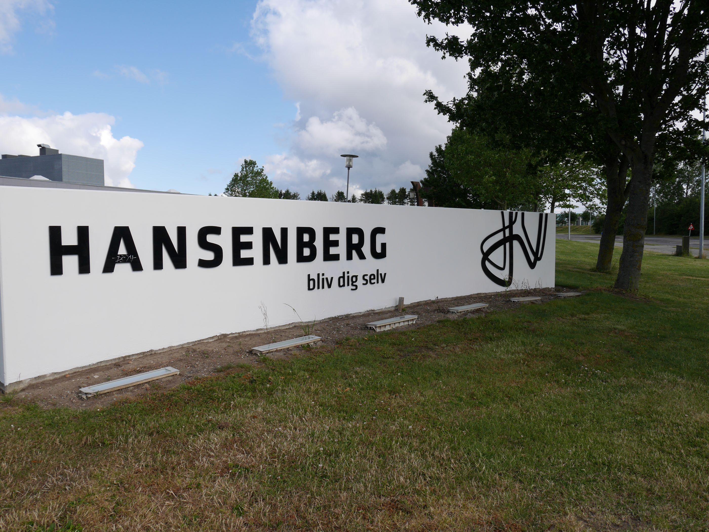 Hansenbergs skilt med logo og teksten 'Bliv dig selv' foran skolens bygninger på C. F. Tietgens Vej.