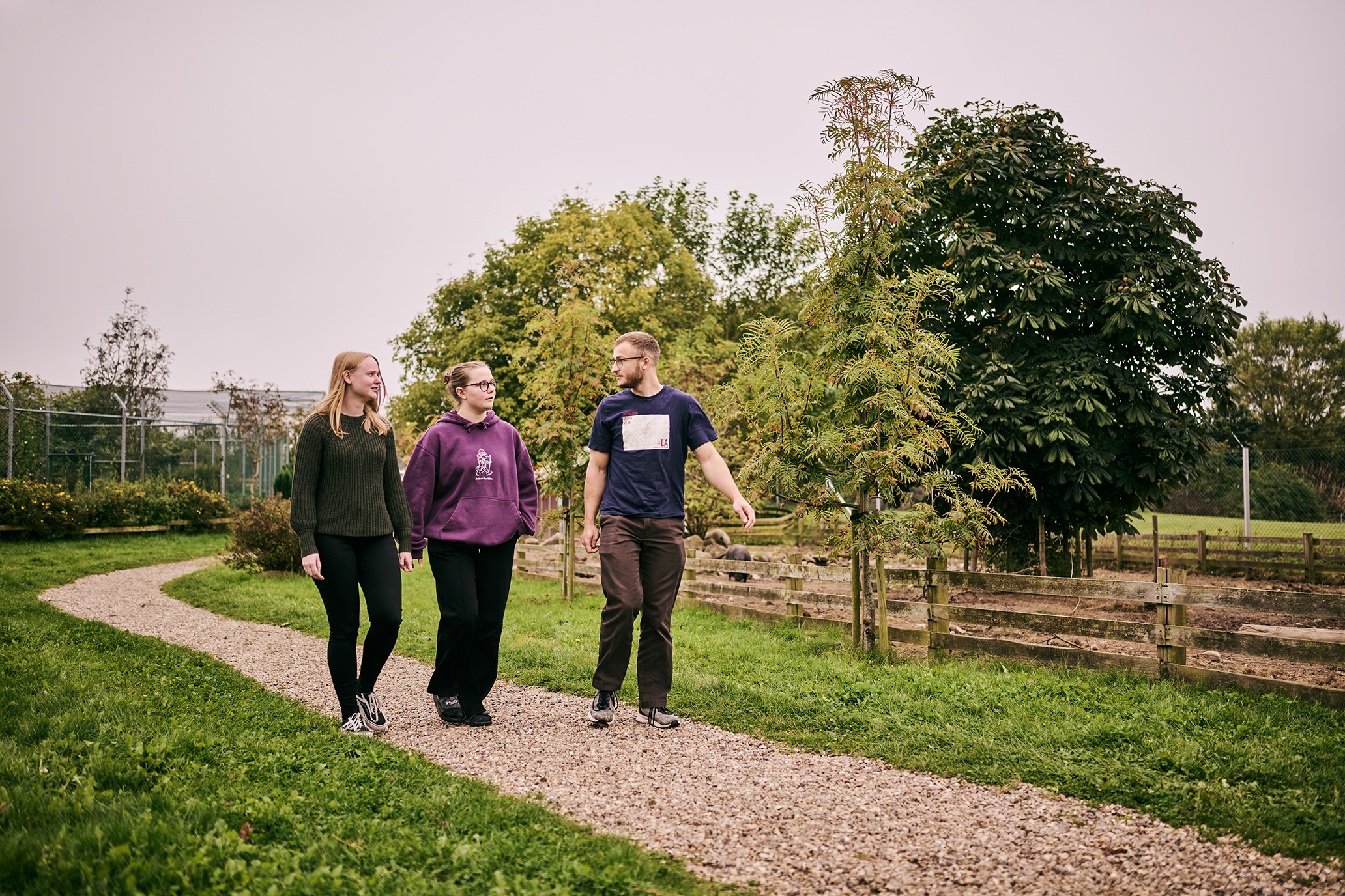Tre elever fra uddannelserne i Vranderup går tur i pausen i skolens zoologiske have.
