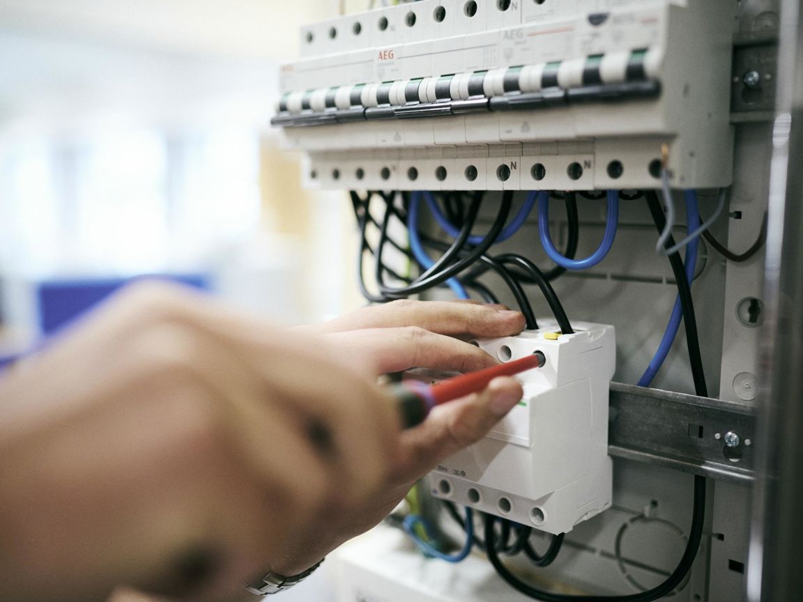 En elektrikerelev er ved at opsætte en en eletavle på skolens værksted.