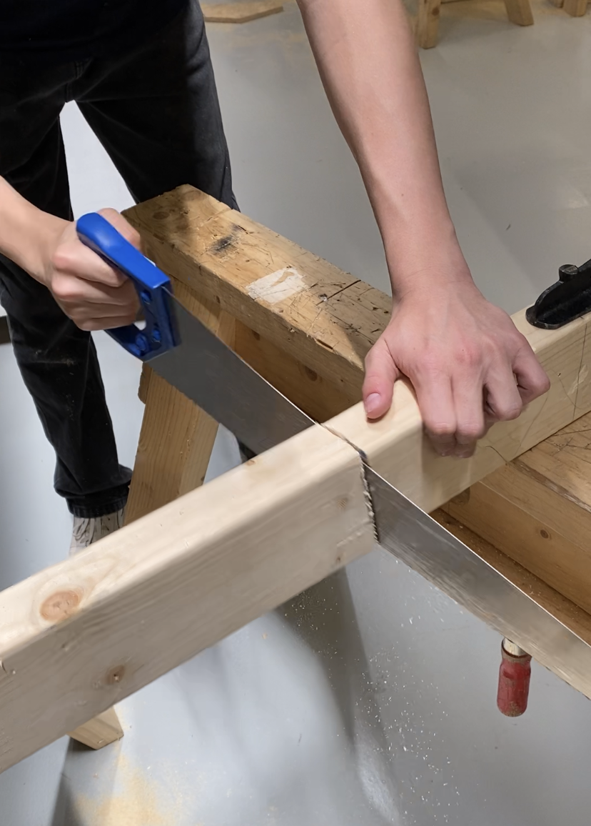 På SommerCampen Byg og Ræs bruger en deltager en sav.