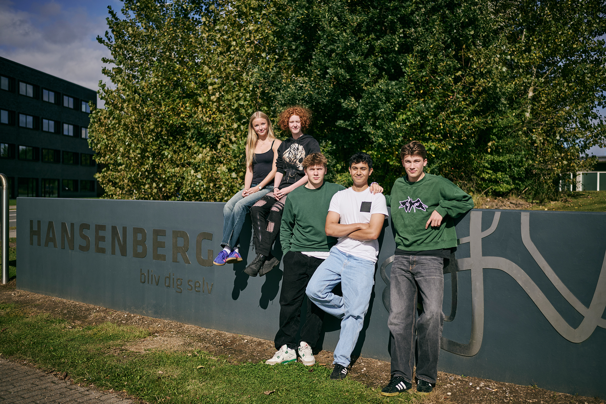 5 elever, der går på Hansenberg Tekniske Gymnasium, står foran Hansenberg-skiltet på Skovvangen 28 i Kolding.