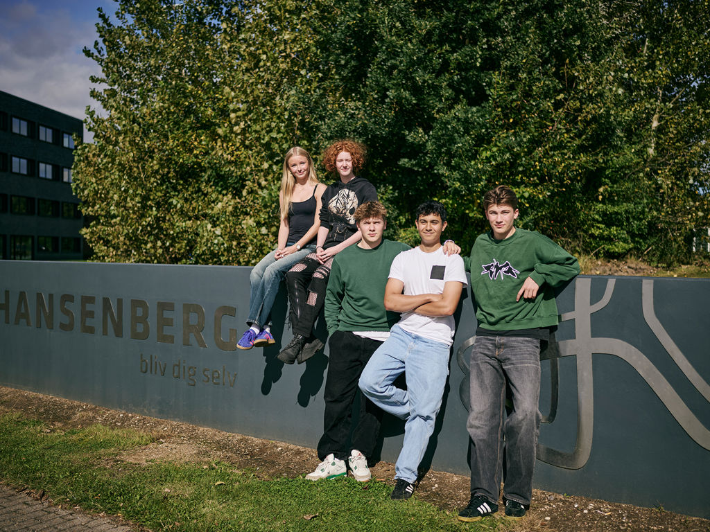 5 elever, der går på Hansenberg Tekniske Gymnasium, står foran Hansenberg-skiltet på Skovvangen 28 i Kolding.