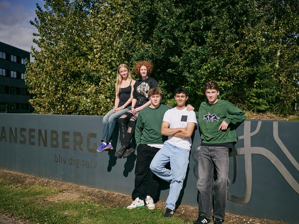 5 elever, der går på Hansenberg Tekniske Gymnasium, står foran Hansenberg-skiltet på Skovvangen 28 i Kolding.