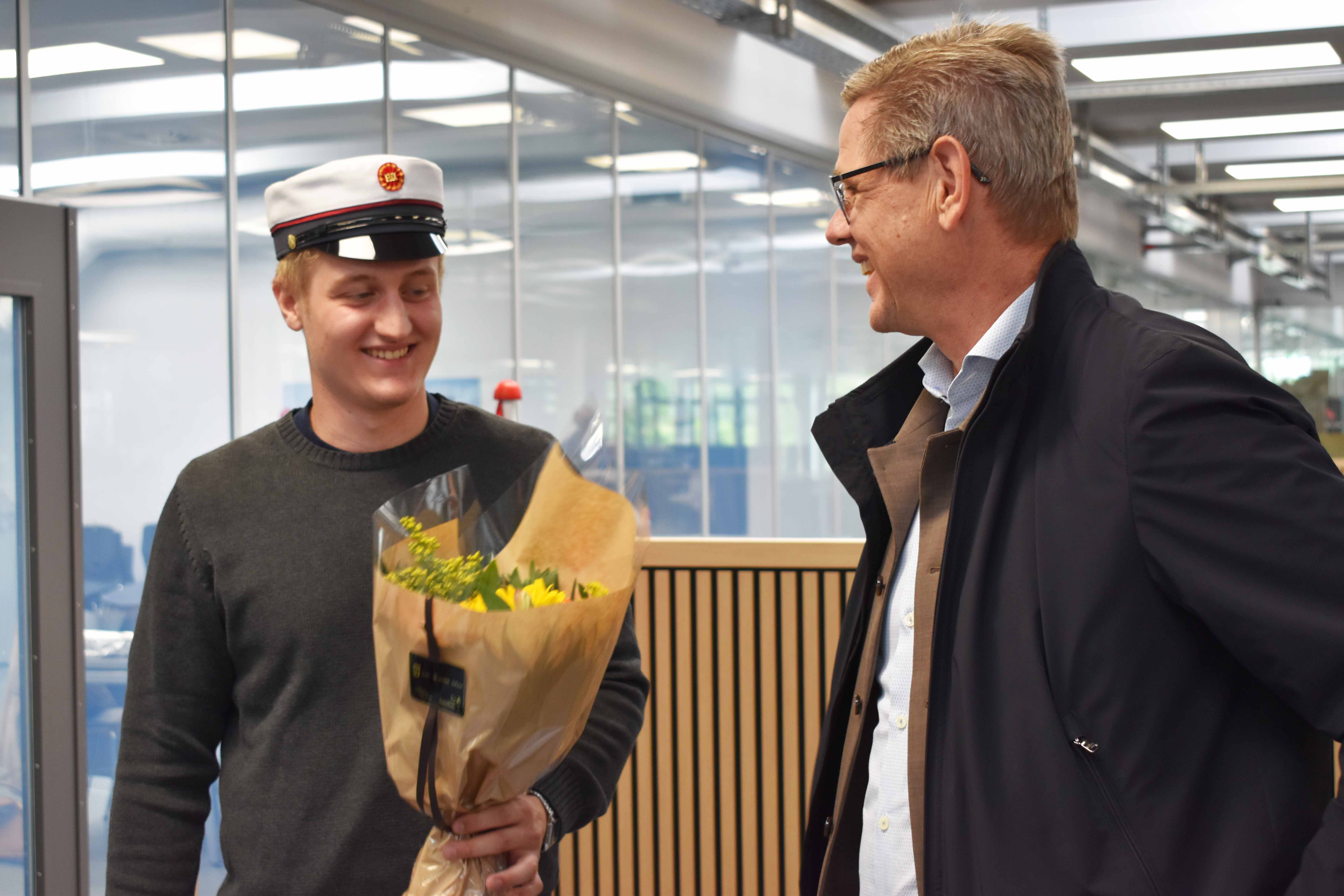 Andreas Bøving får blomster af rektor Mads Stendorff.