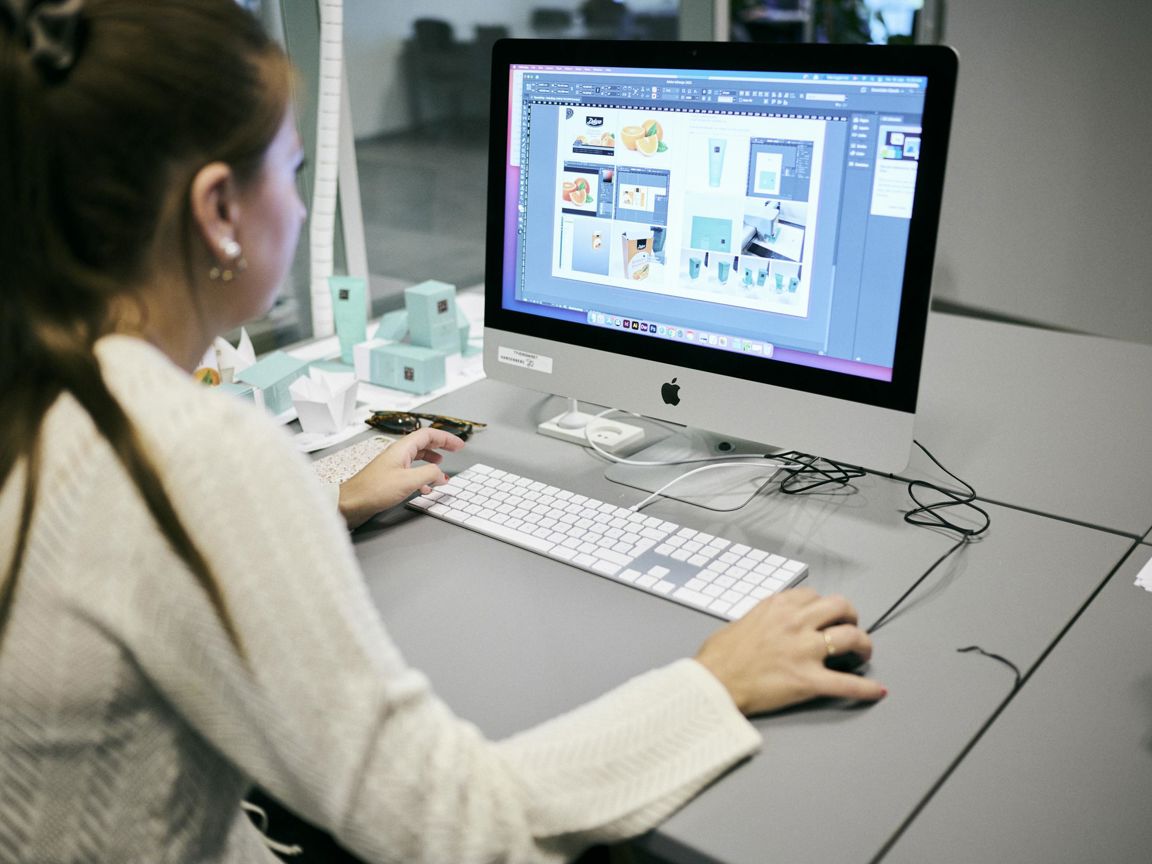 En mediegrafikerelev på Hansenberg designer små æsker med tryk på en af skolens iMacs.