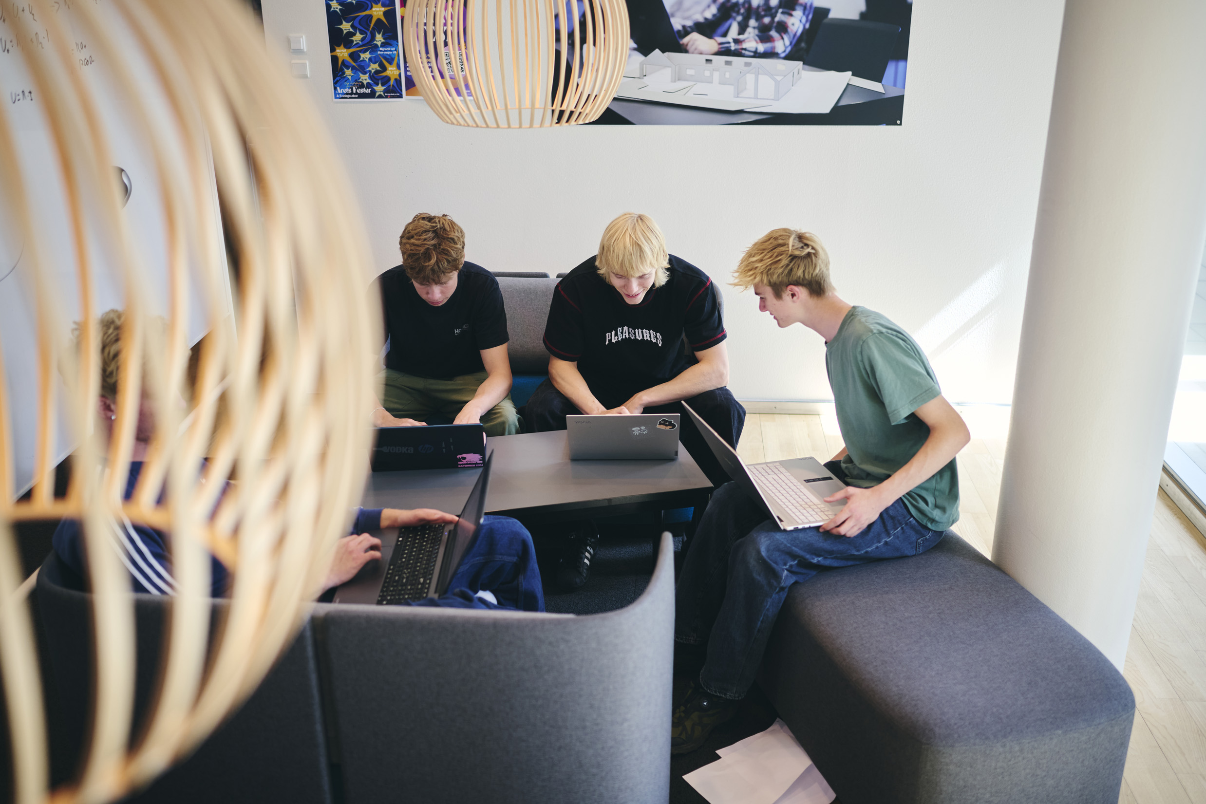 Der er gruppearbejde på HTX, og nogle af skolens elever arbejder med deres bærbare i en af sofagrupperne.