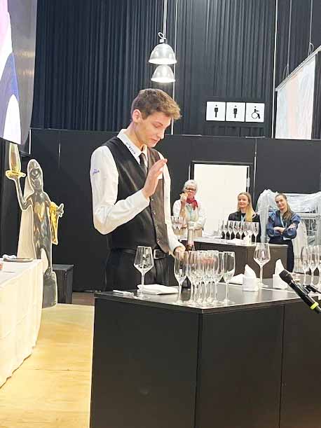 Magnus Dahl Rehnquist er tjenerelev på HANSENBERG, og her hælder han mousserende vin op.